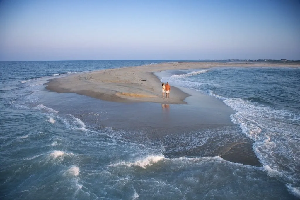 couple standing on a sand bar on bald head island, one of the most romantic getaways in nc