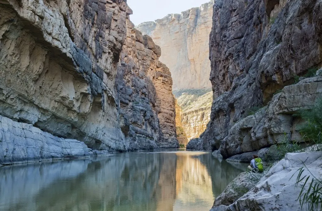 hiker sitting in santa elena canyon in big bend np, one of the most underrated usa national parks