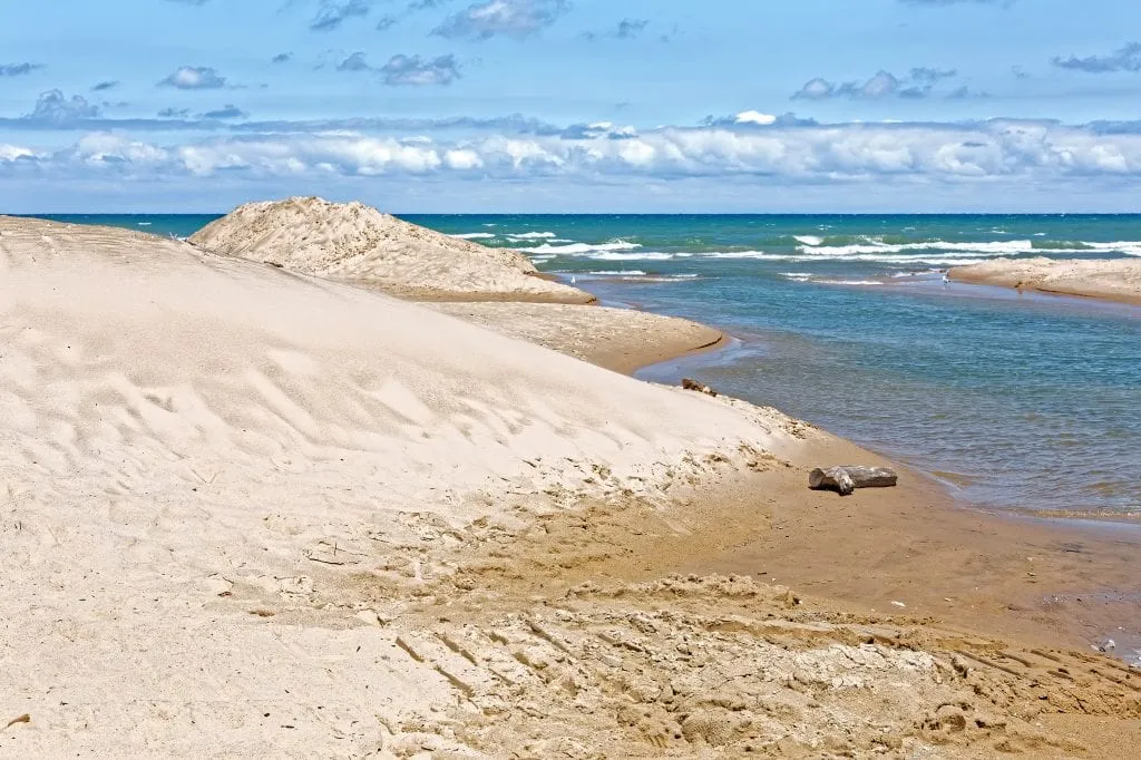 white sand beach at indiana dunes with bright blue water on the right