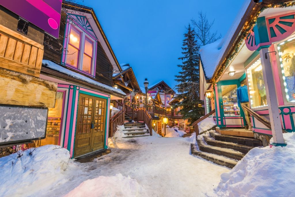small street in breckenridge in winter, with snow on the ground and christmas lights up