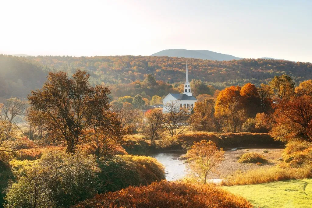 white church in stowe vermont in the fall, surrounded by fall foliage