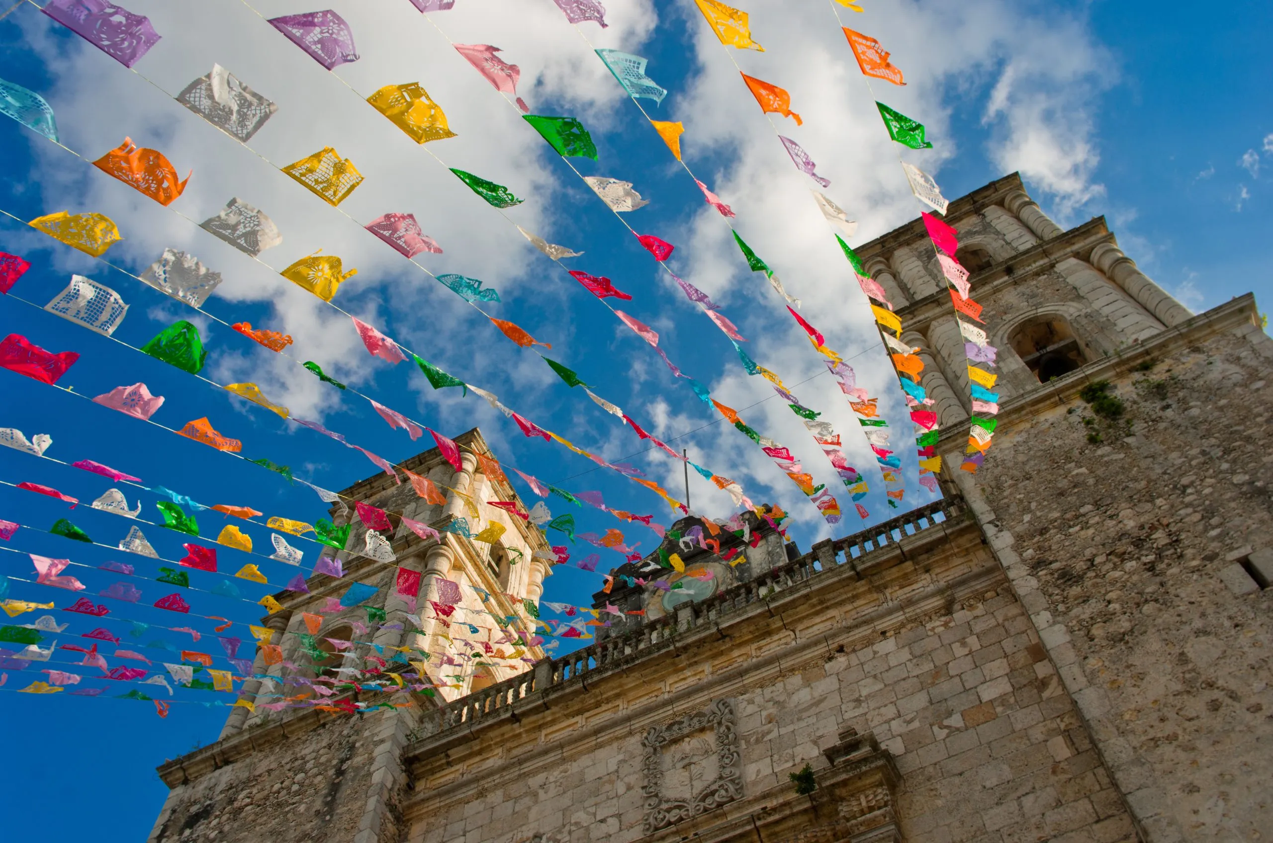 colorful flags on iglesia de san servacio, one of the most fun things to do in valladolid mexico