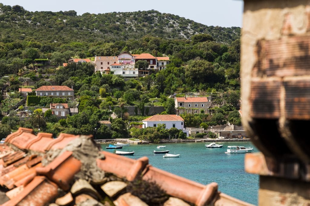 harbor of kolocep croatia as seen across red tiled rooftops