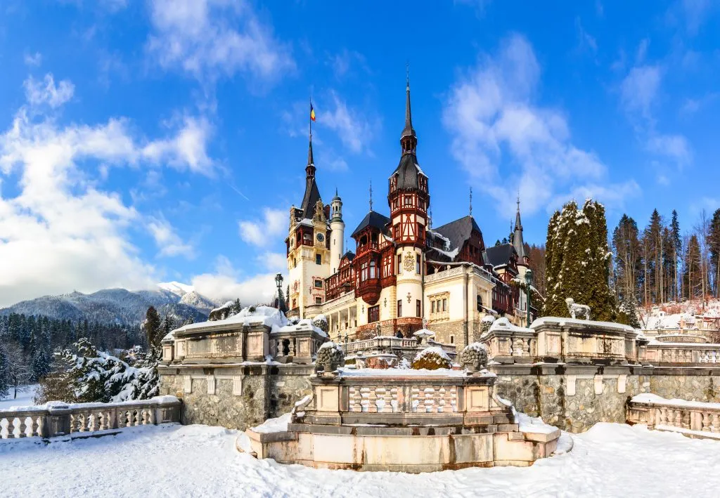 peles castle romania in winter after a snowfall, one of the best bucket list europe travel destinations