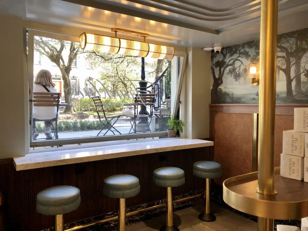 interior of franklins in savannah with barstools in the foregound and outdoor tables visible outside the window
