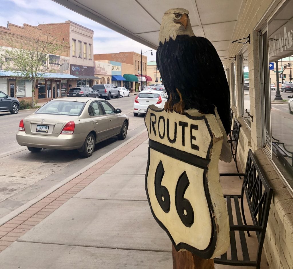 carved bald eagle statue with route 66 sign in downtown winslow arizona