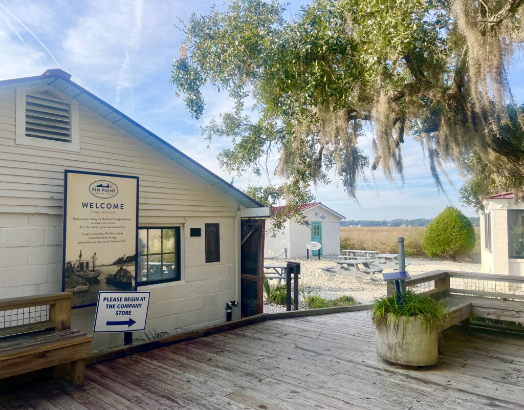 exterior of pin point heritage museum showing buildings, marsh, and spanish moss dripping from oak tree