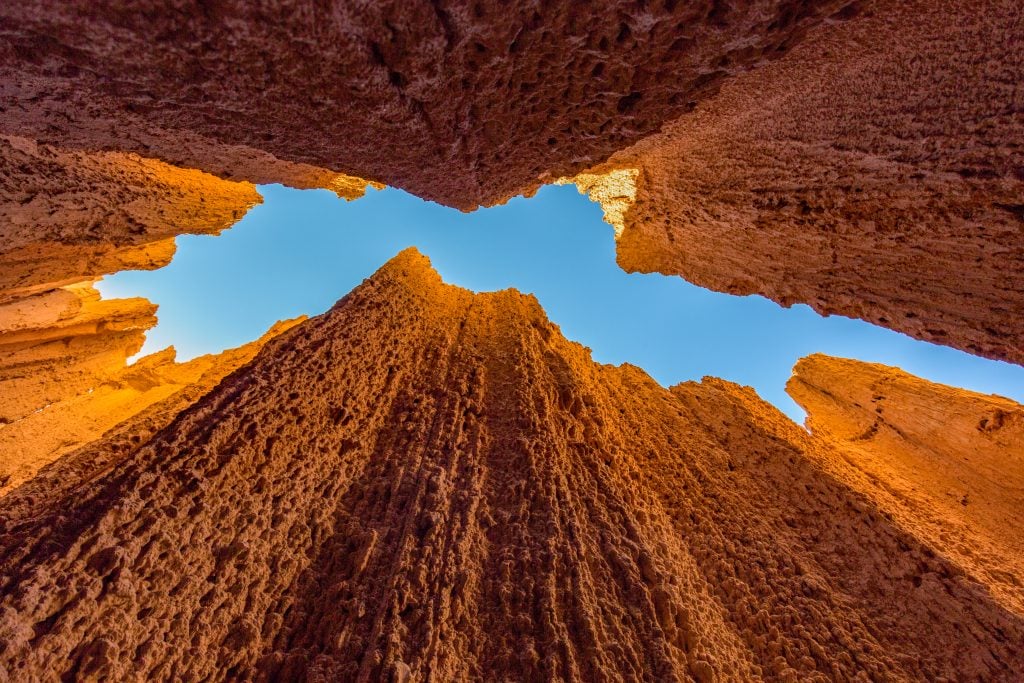 view of blue sky looking up through rock formations in cathedral gorge nevada, a fantastic stop on a southwest road trip itinerary