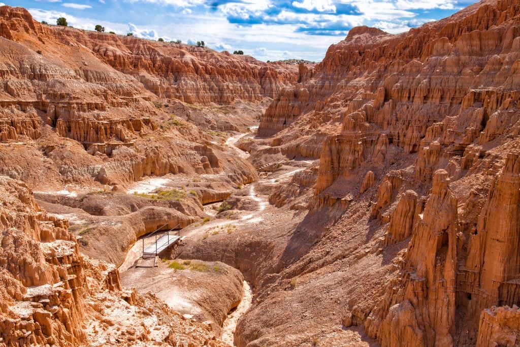 view of a trail in cathedral gorge state park with a small bridge in it