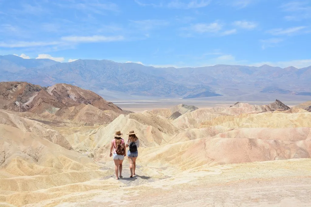 two women hiking through the desert of death valley, a popular us southwest road trip destinations