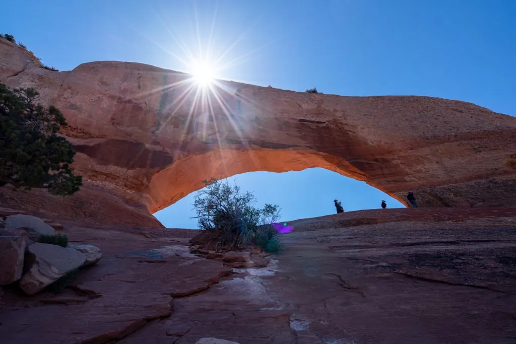 view of wilson arch moab looking up with sun flare