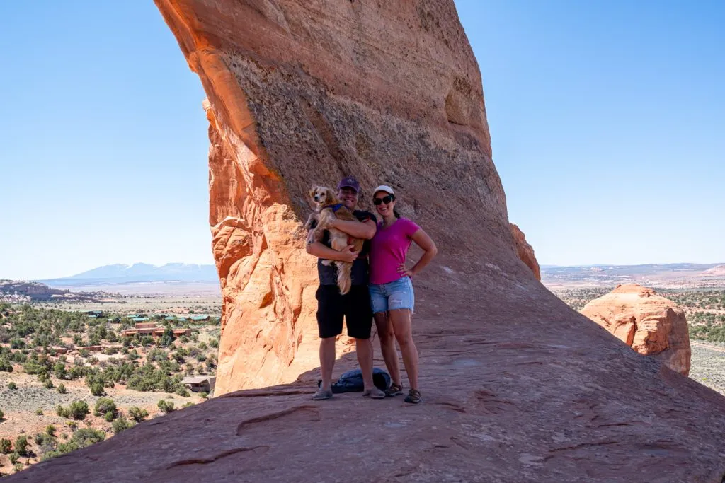 kate storm, jeremy storm, and ranger storm posing in front of wilson arch moab utah
