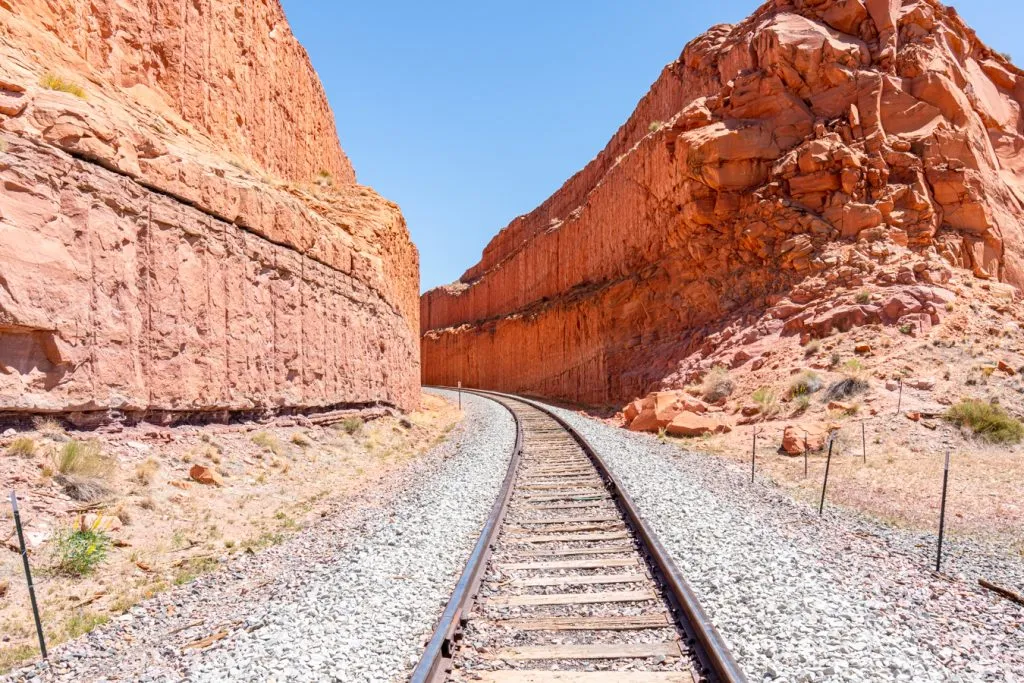 railroad tracks leading into a sandstone tunnel in utah