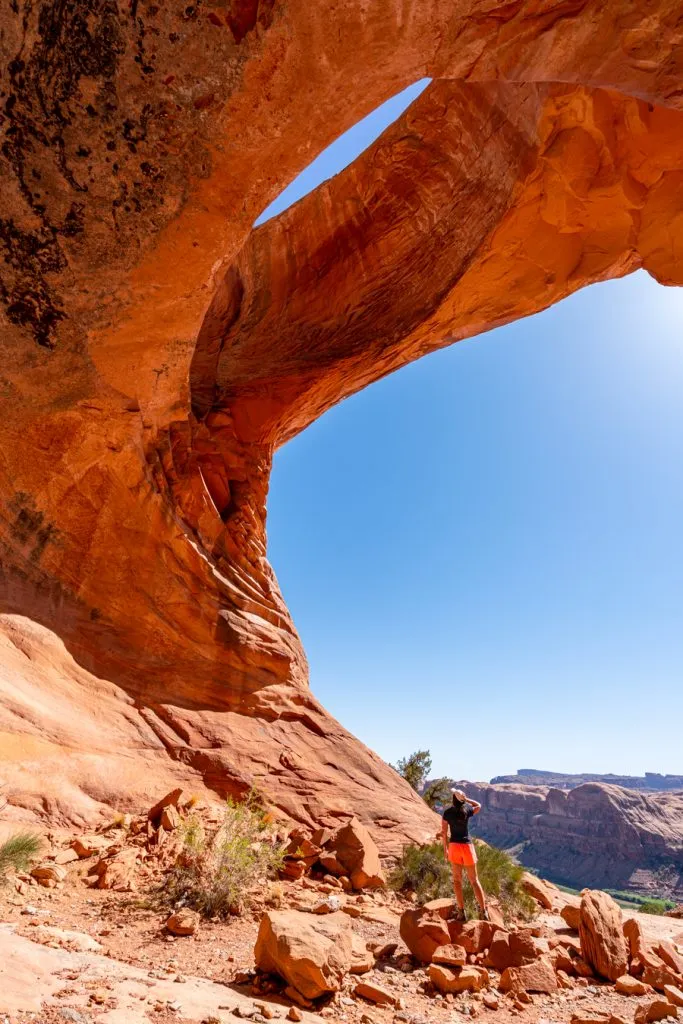 kate storm standing underneath pinto arch moab utah