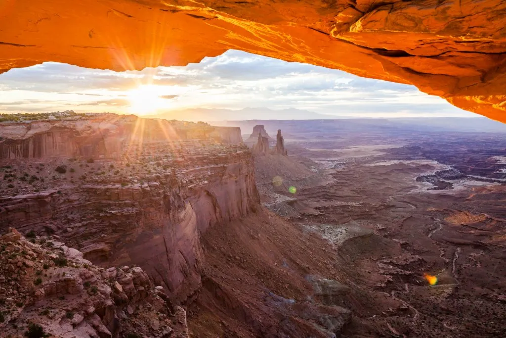 sunrise over mesa arch in canyonlands np with a sun flare