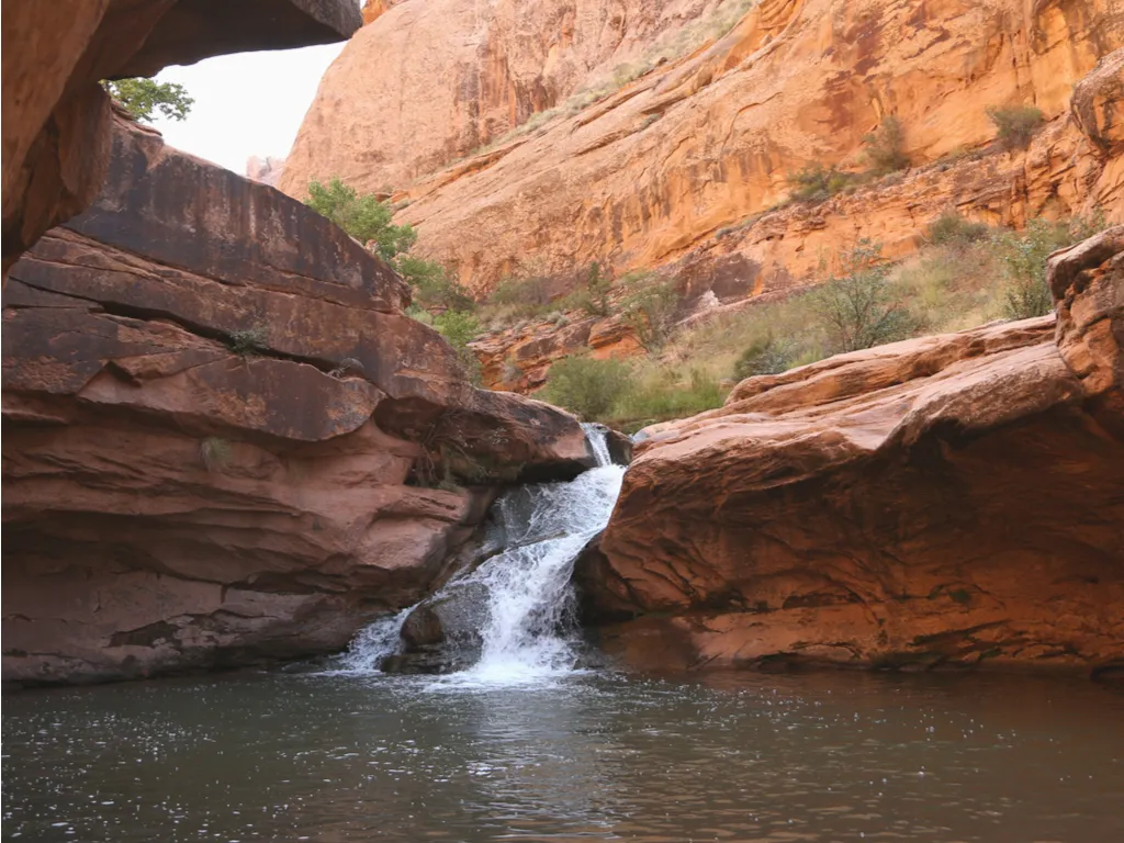 small waterfall and swimming hole along mill creek falls trail, a great way to cool off when deciding what to do in moab