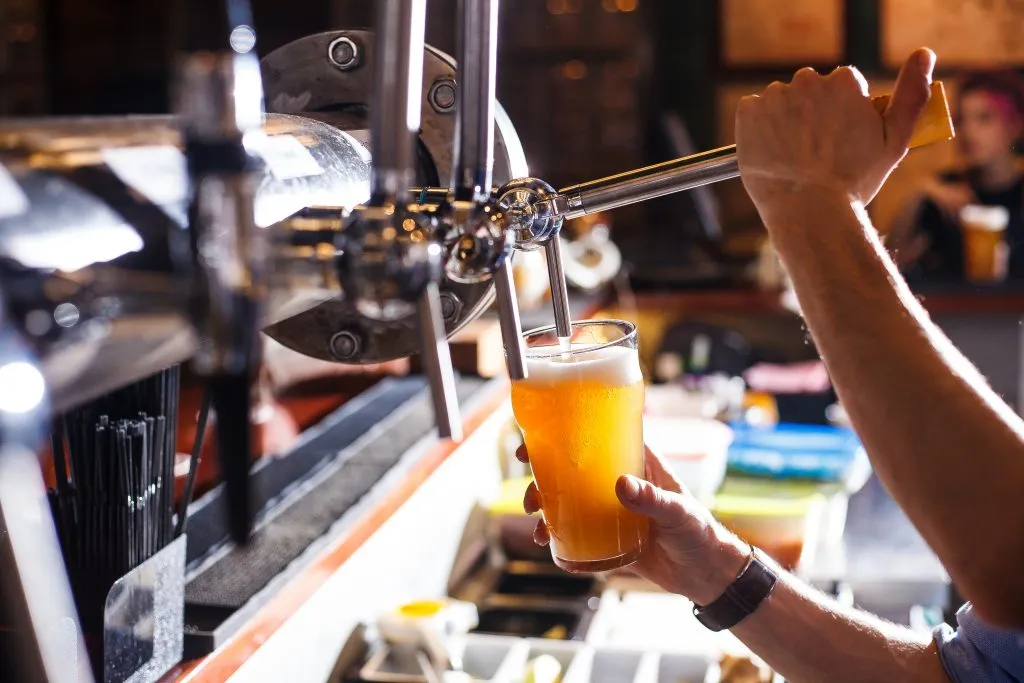 glass of beer being pulled at a brewery