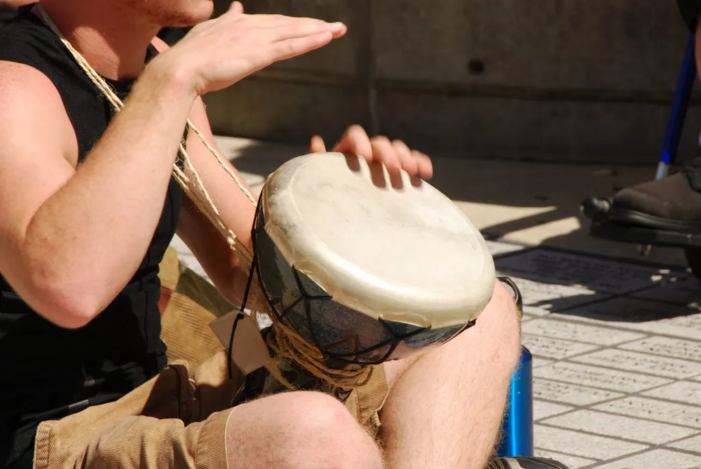 man playing a small drum in a drum circle