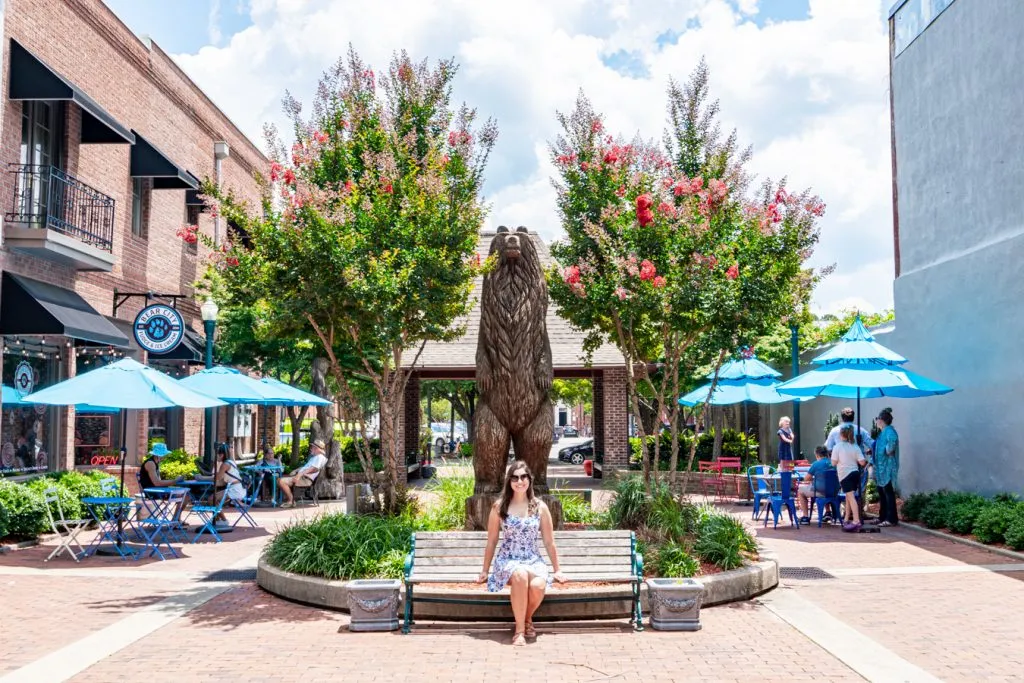 kate storm in downtown new bern with a bear statue behind her