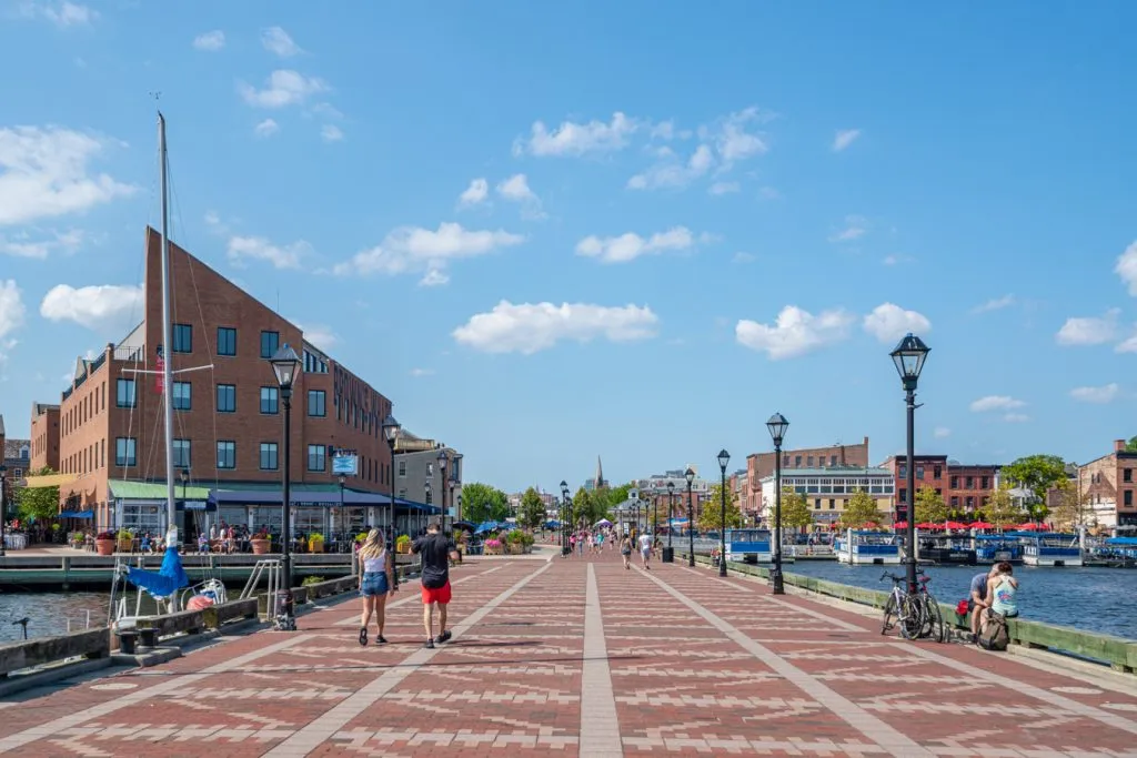 people walking along a paved pier in fells point, one of the best places to visit in baltimore in 2 days