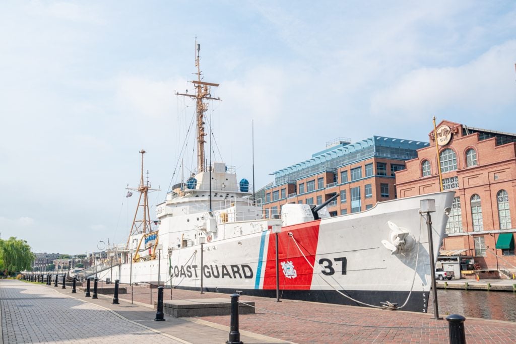 historic white and red coast guard ship in inner harbor baltimore on the weekend