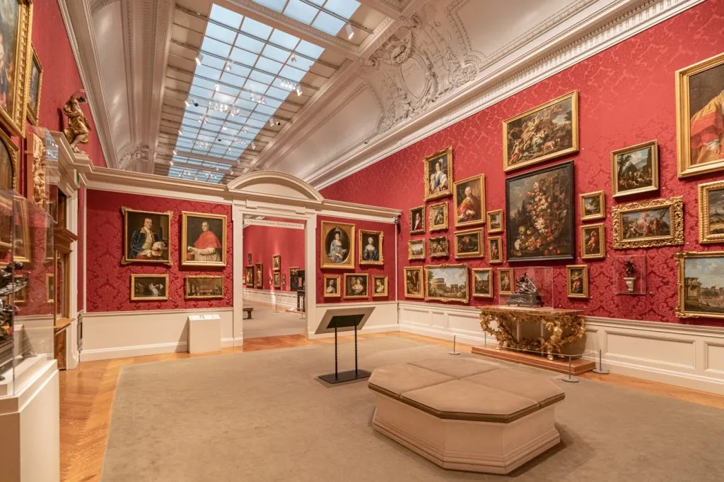 collection of renaissance paintings on display in a room painted red in walters art museum, as seen during a baltimore weekend trip