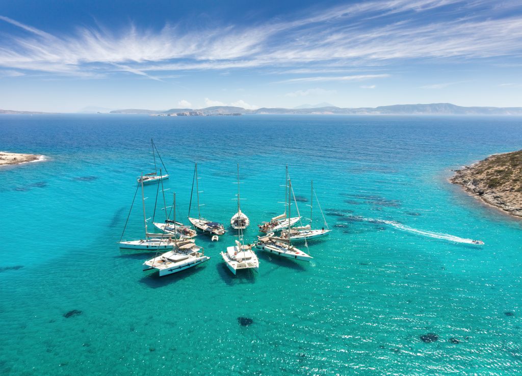 collection of sailboats gathered together in the waters of greece