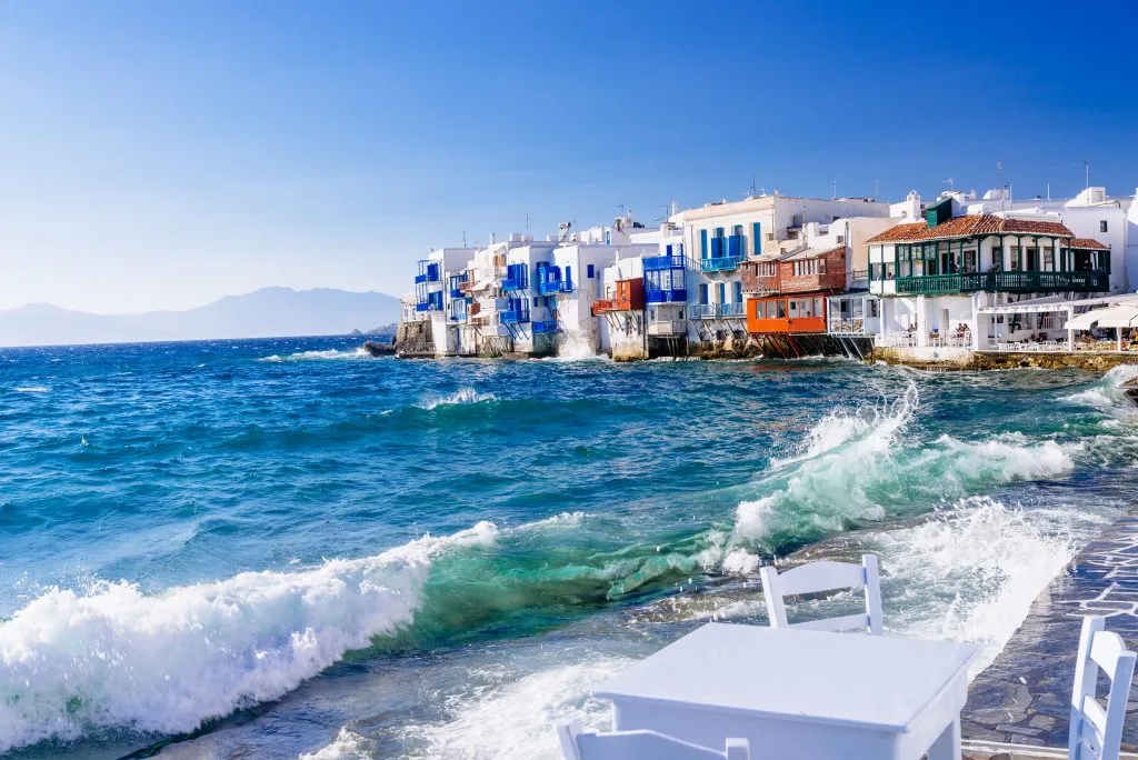 seaside view in mykonos greece with whitewashed buildings in the background, one of the best places to visit in greece island hopping itineraries