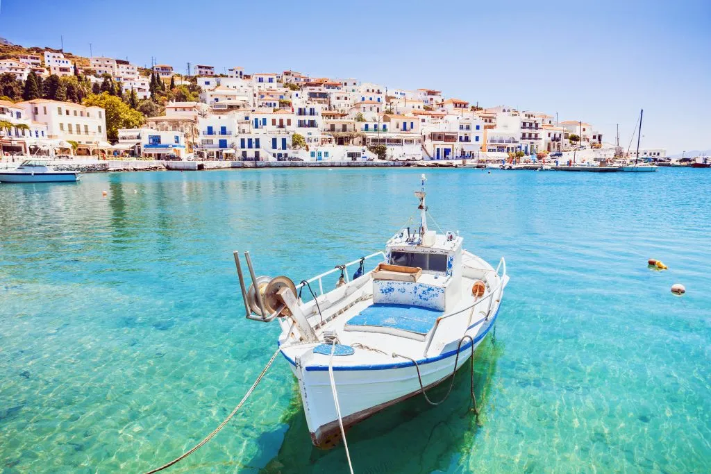 view of andros greece with the sea and a fishing boat in the foreground