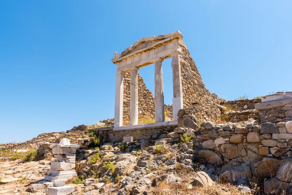 ancient ruins on delos island, with a set of four columns prominent in the photo