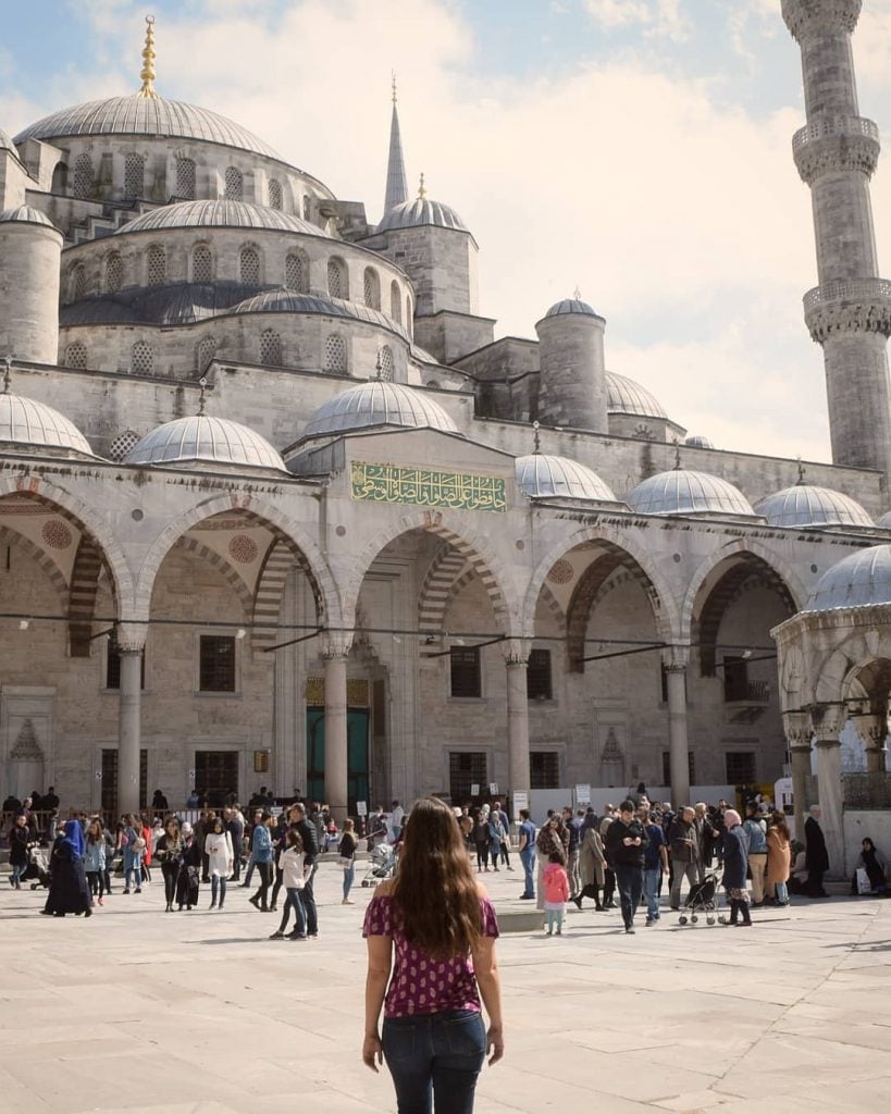 kate storm standing in front of the blue mosque, one of the best things to do in istanbul turkey