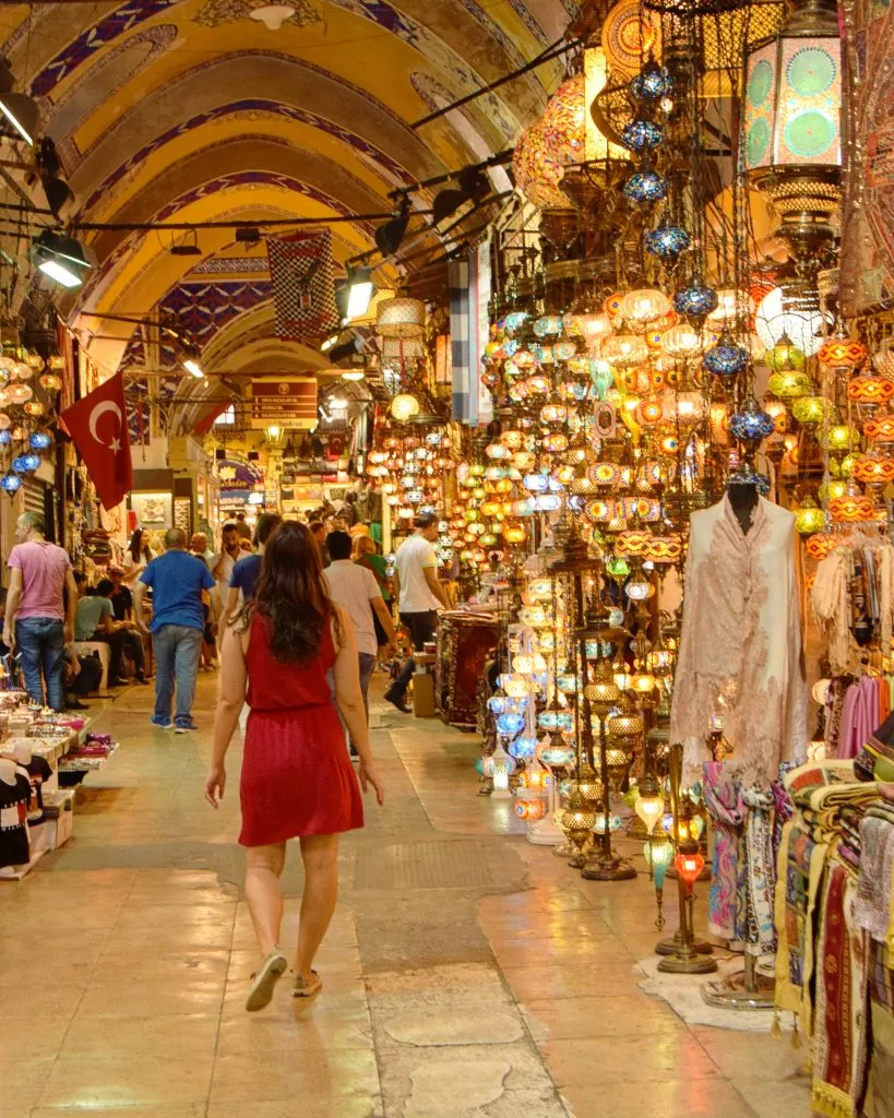 kate storm in a red dress walking through istanbul grand bazaar, one of the best places to visit in istanbul turkey