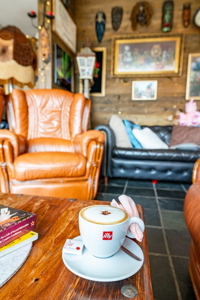 cozy cafe with coffee and a leather chair in iceland, a great place to try out travel journal prompts and other travel journal ideas