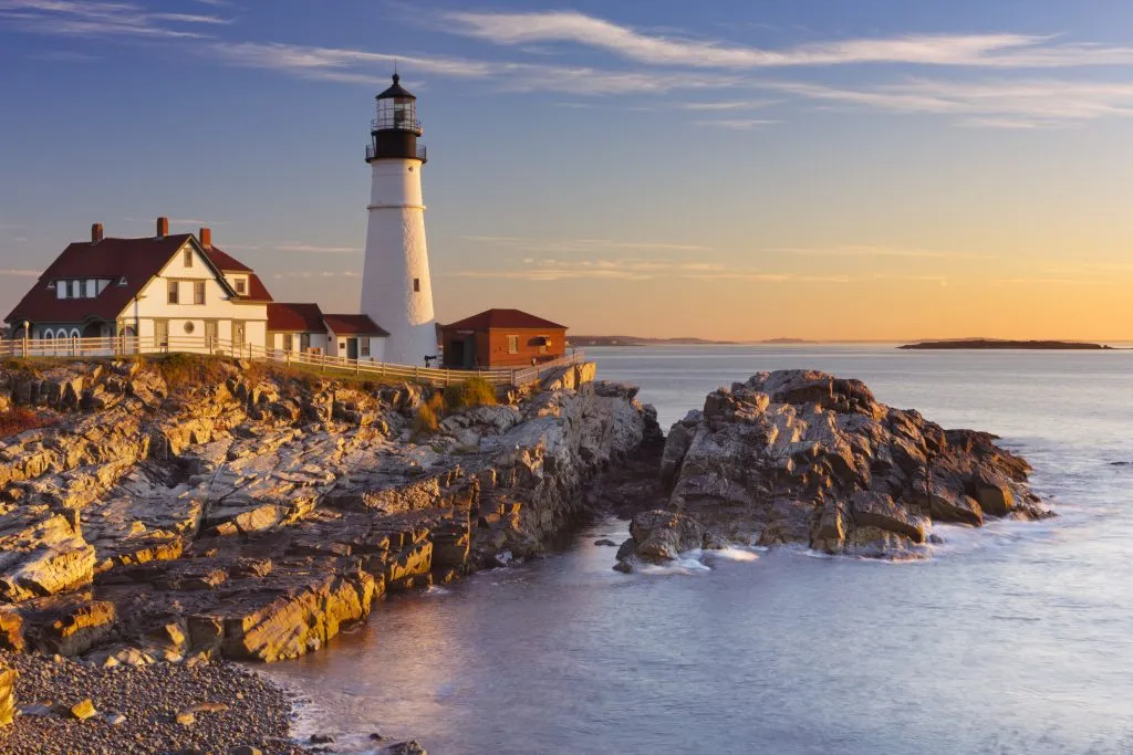 lighthouse in portland maine at sunset with ocean in the foreground, one of the best things to do in the us