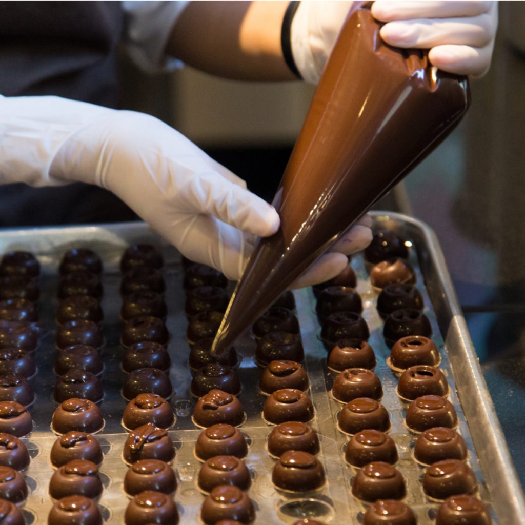 person making a pan of chocolate candies