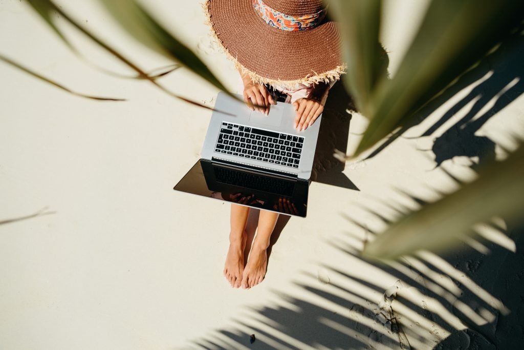 woman working while traveling on the beach