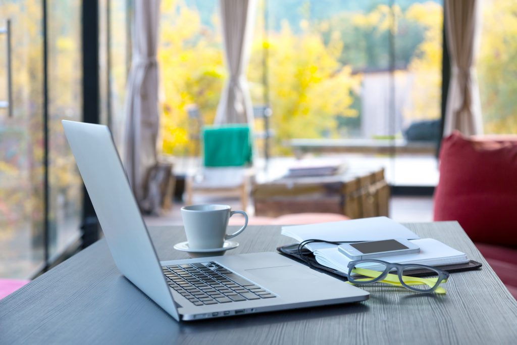 laptop on a table in a coffee shop, work and travel combination