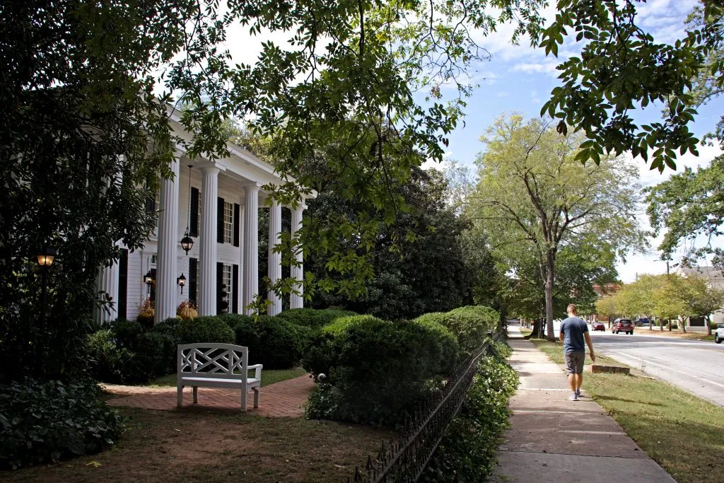 historic white home with people walking in front of it in covington ga