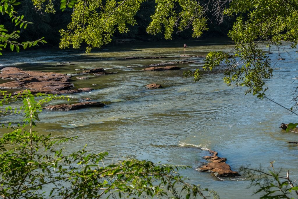 chattahoochee river, one of the prettiest places in georgia usa, with a fly fisher in the river