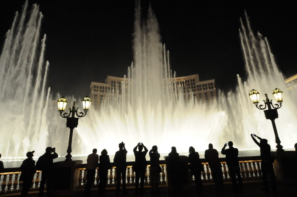 crowd of people observing bellagio fountain show at night, one of the best weeked las vegas attractions