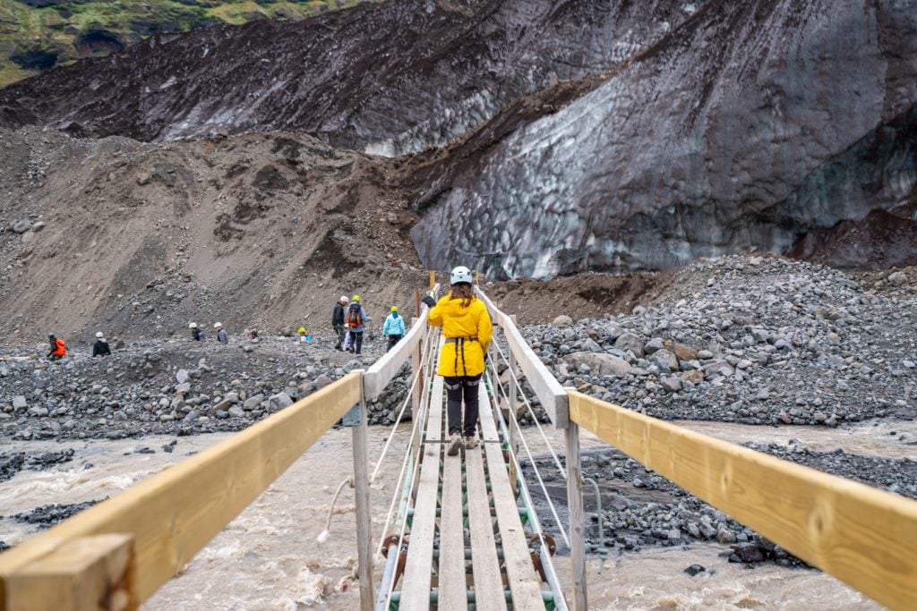 narrow wooden bridge leading across the river when approaching vatnajokull glacier hiking iceland
