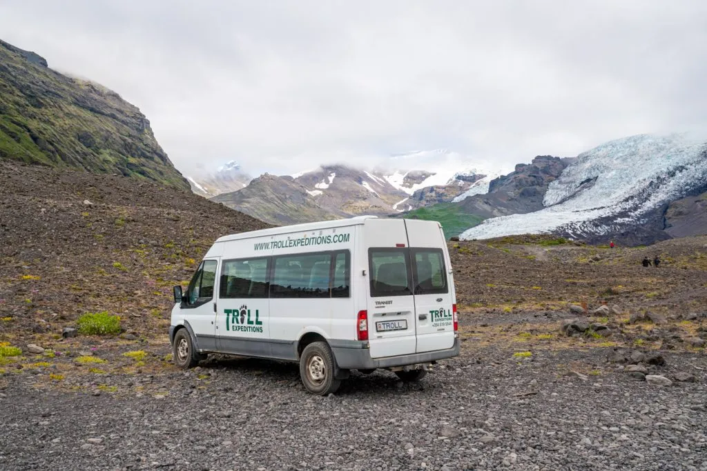 troll expeditions van parked on a dirt road with vatnajokull glacier visible in the background