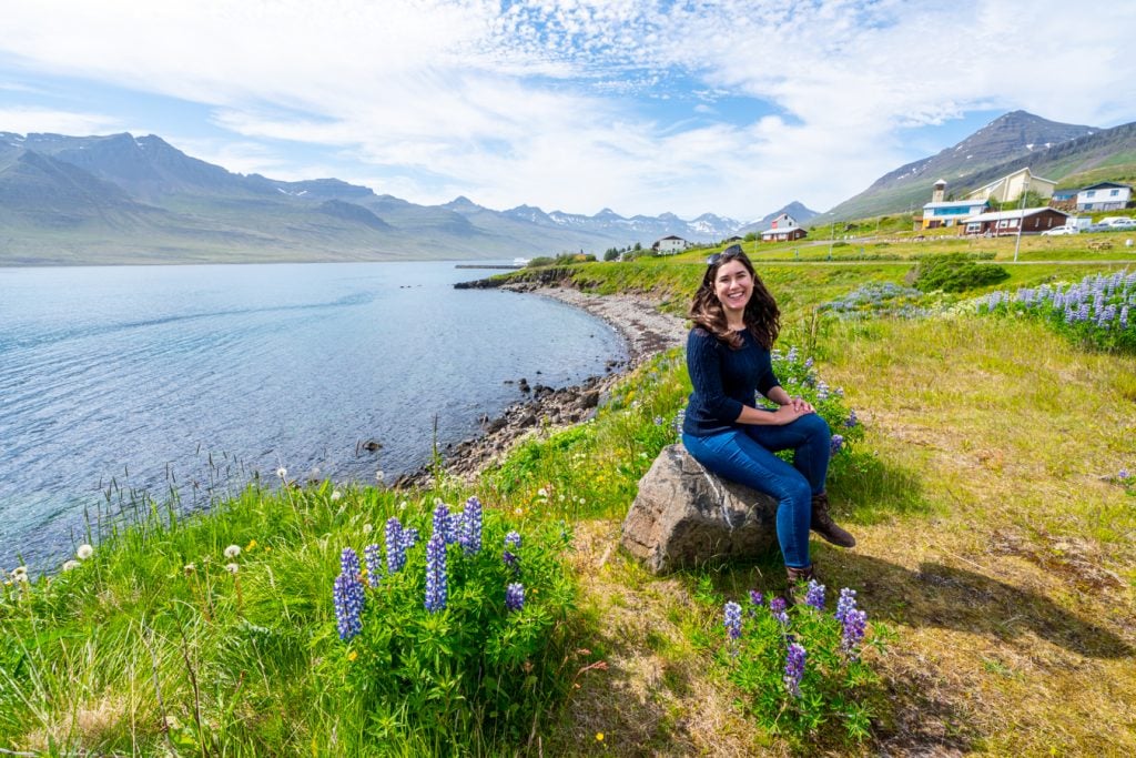 kate storm sitting next to lupines in iceland