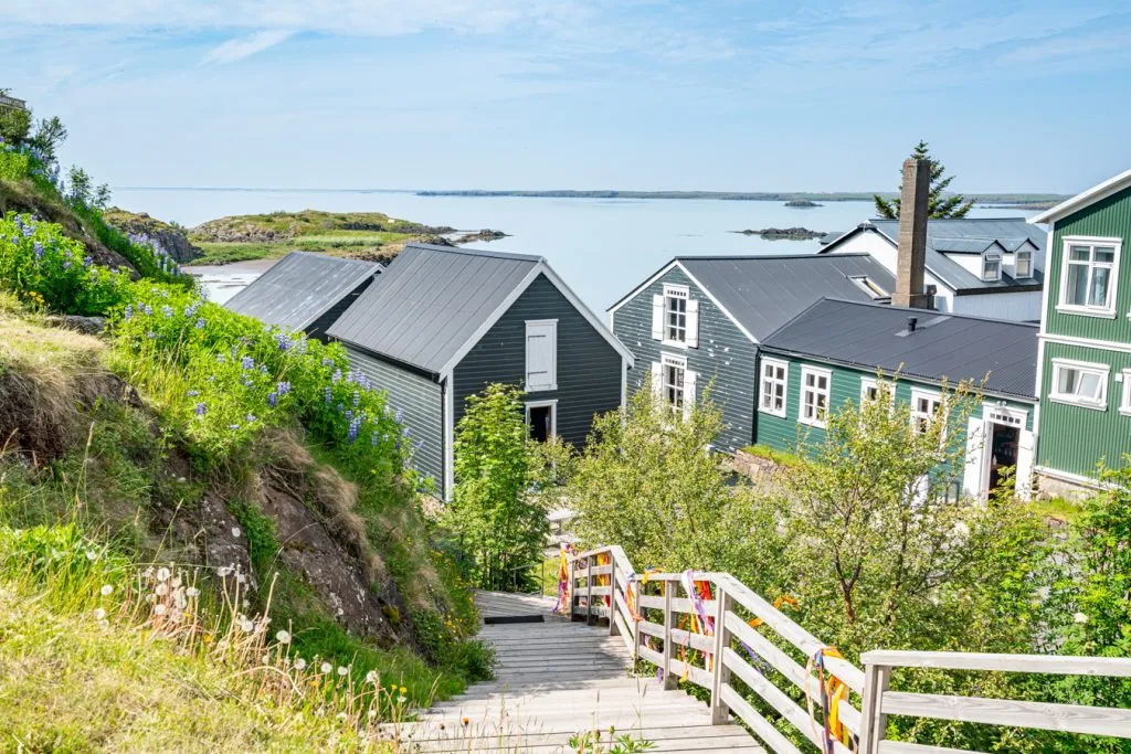 group of gray buildings leading to water in a small village iceland