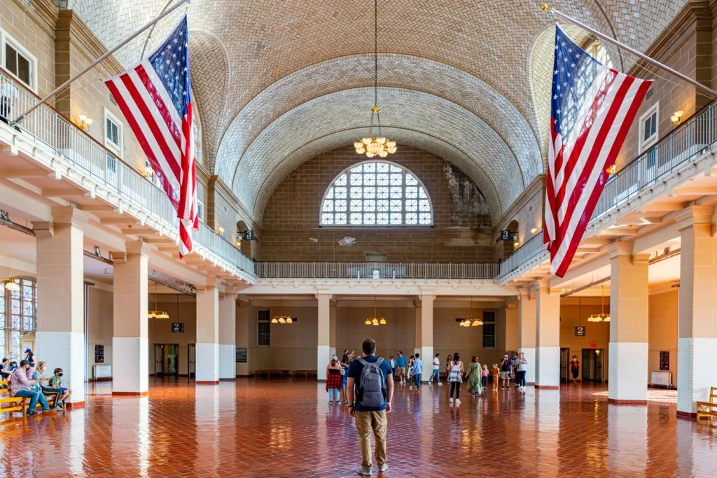 jeremy storm walking through main processing room on ellis island new york city