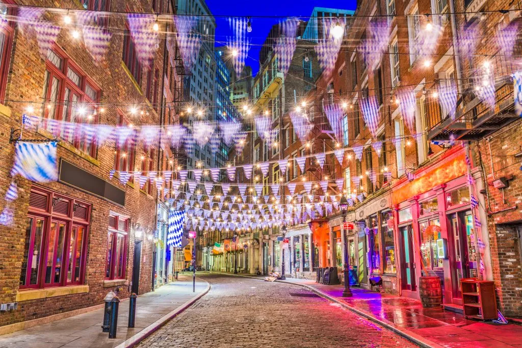 long exposure of stone street nyc at night with flags hanging over the street