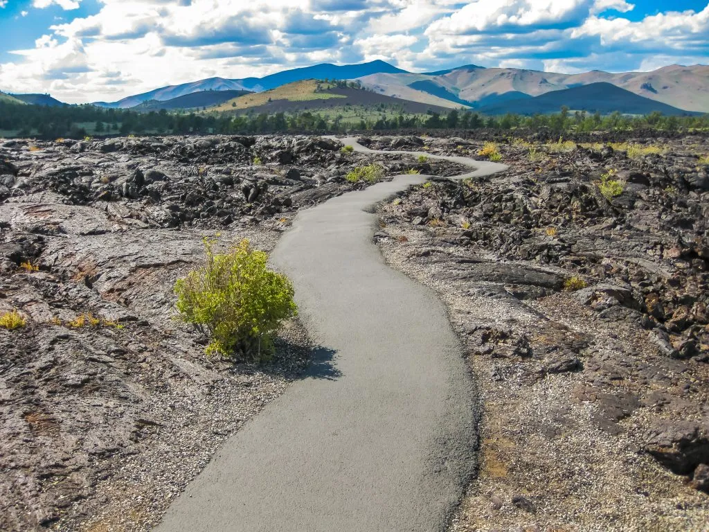 paved trail winding through volcanic landscape craters of the moon national monument
