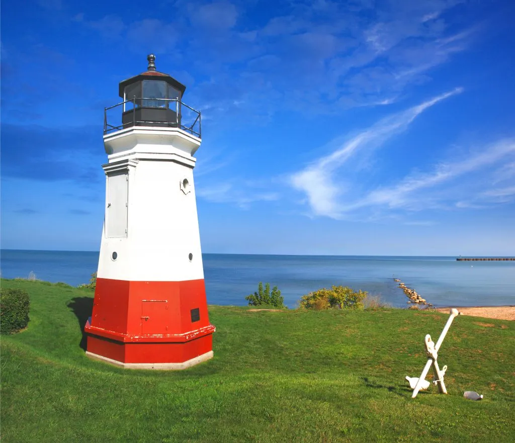 red and white lighthouse in vermilion ohio with lake erie in the background