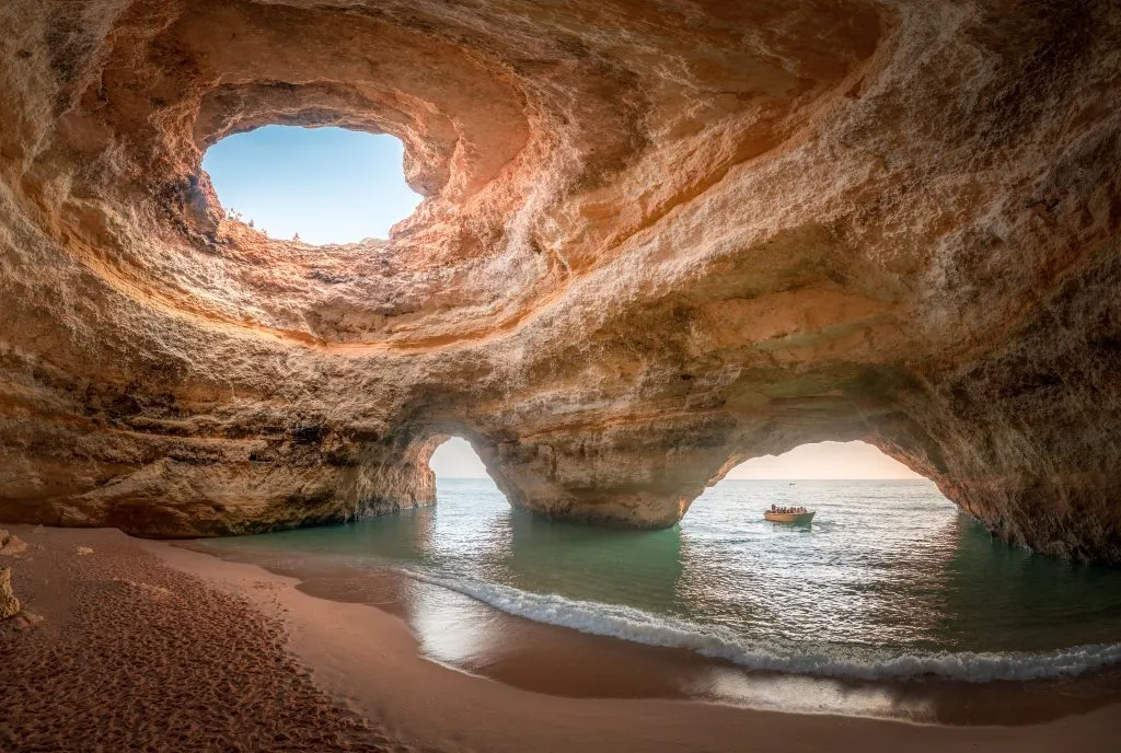 benagil cave in algarve portugal with a small boat entering by water