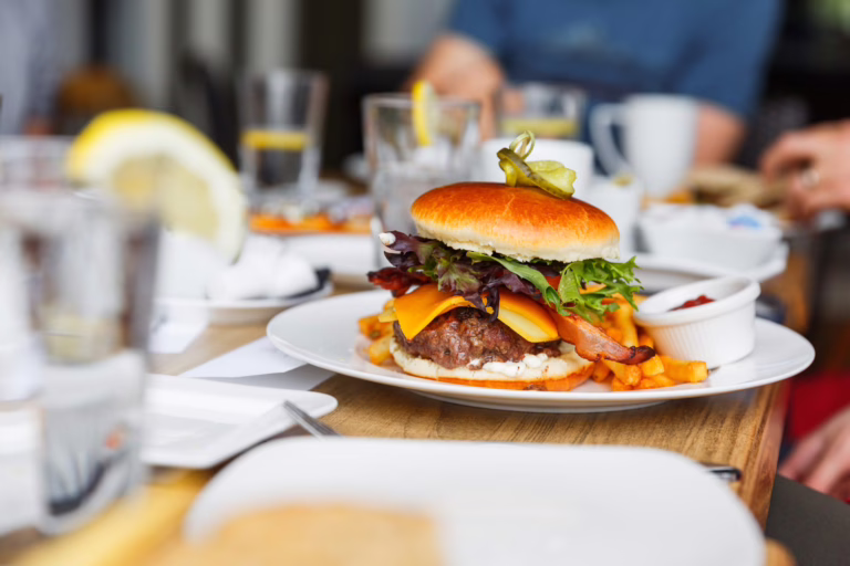 burger on a patio with water glasses surrounding it at best moab restaurants